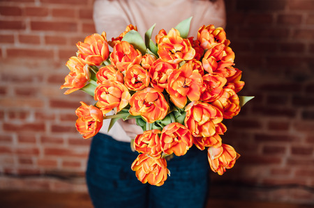 bouquet of orange tulips on the brick wall backgroundの写真素材