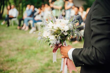 Beautiful wedding bouquet in hands of the groom.の写真素材