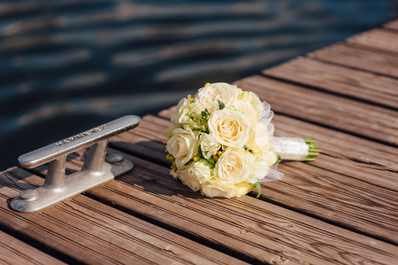 Bridal bouquet of roses on a  brown wooden planksの写真素材