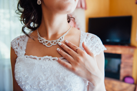 bridesmaids help to wear a wedding dress in the morningの写真素材
