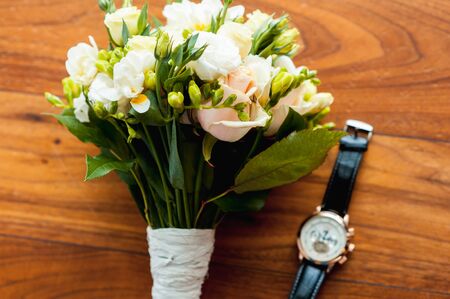 bridal bouquet and premium men's watches on the wooden floorの写真素材