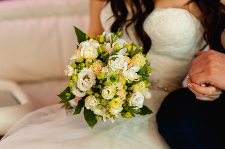beautiful bouquet in hands of the bride is very stylish with light hairの写真素材
