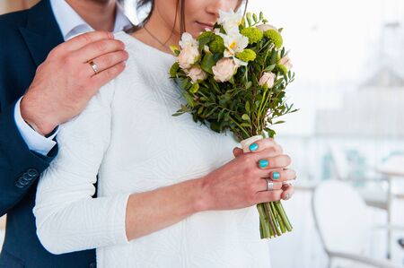 Bride and groom holding wedding bouquet together . Hug . beautiful hairの写真素材