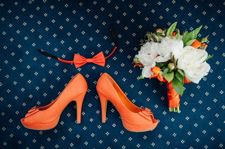 the bow tie, bouquet and shoes in orange color on  a blue matの写真素材
