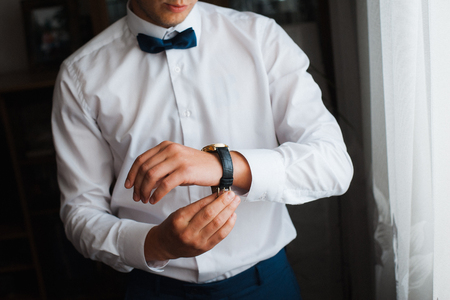 groom clasping stylish watch band on his wrist.の写真素材
