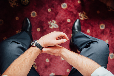 a man sits with hands clasped . View from aboveの写真素材