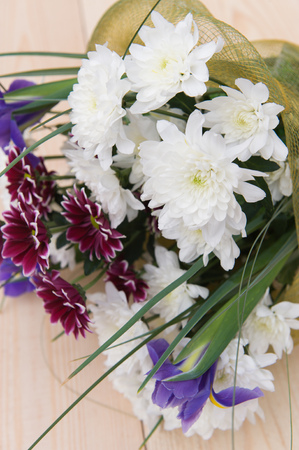 beautiful spring bouquet of flowers with chrysanthemums on a wooden plateの写真素材