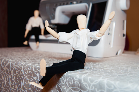 wooden figurine of a man in a white shirt near the sewing machine.の写真素材