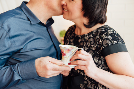 senior husband and wife holding a cup of tea together.の写真素材