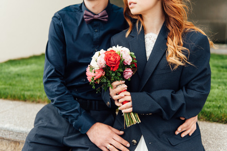 Bride and groom holding wedding bouquet together . Hug . beautiful hair