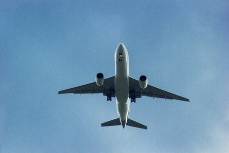 An airplane flying in the blue sky with clouds