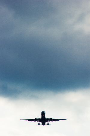 An airplane flying in the blue sky with clouds