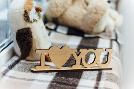 Vintage wooden inscription Love with beautiful bouquet of flowers on the brown background. Text Love, Fill me, You're my one, I love you.の写真素材