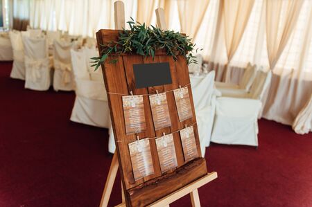 Original vintage wooden board with decoration and ribbons and a guest list, heart and bucket in the...