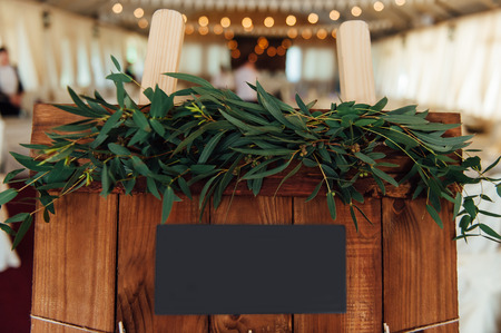 Original vintage wooden board with decoration and ribbons and a guest list, heart and bucket in the background. with a place for an inscriptionの写真素材
