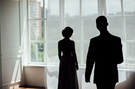 silhouette of a girl near the window , which is waiting for her boyfriendの写真素材
