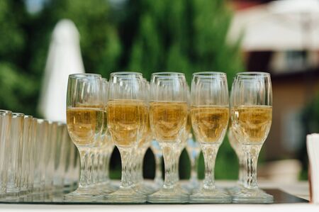 Wedding glasses filled with champagne at the banquetの写真素材