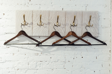 Wood coat hanger on a white brick wallの写真素材