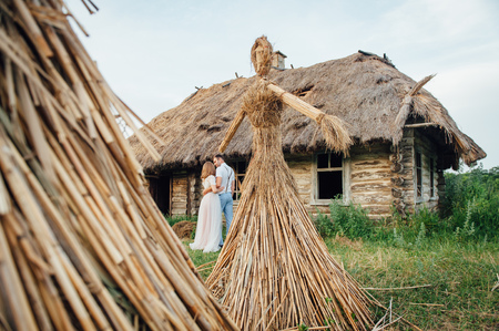 large Ukrainian handmade doll amulet is a mascot for happiness and vital power near a wooden houseの写真素材