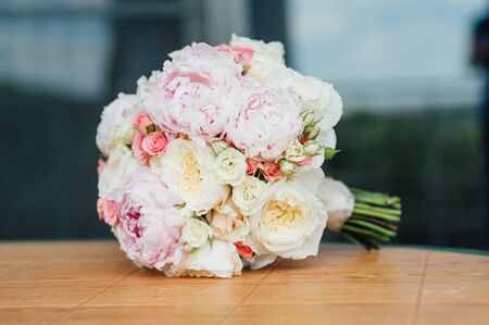 Bridal bouquet of peonies on a brown wooden planksの写真素材