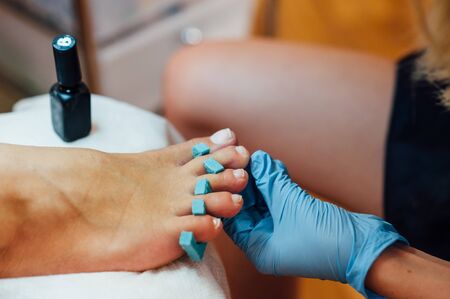 Master pedicure in sterile gloves shapes nails and cuticles closeup . Hardware manicure. Concept body care.の写真素材