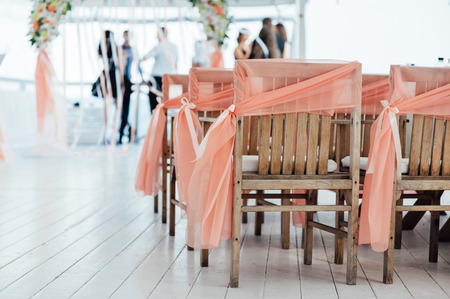 Wedding ceremony decoration in sunset. with wooden chairsの写真素材