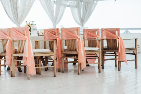 Wedding ceremony decoration in sunset. with wooden chairsの写真素材