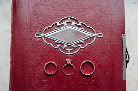 Wedding and engagement ring with a diamond on a vintage family bookの写真素材