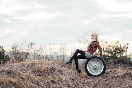 Sexy young girl sits on a large wheelの写真素材