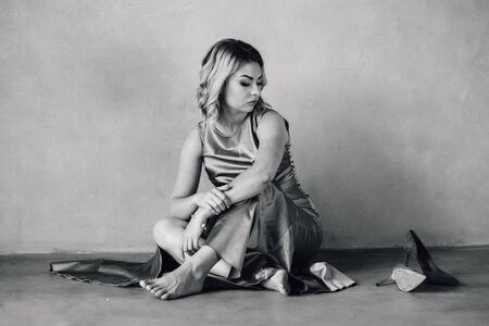 young woman in purple dress sitting on a floorの写真素材