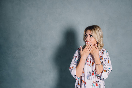 Surprised woman with hand over mouthの写真素材