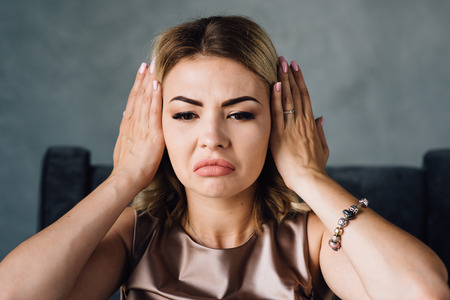 Happy woman covering her ears with handsの写真素材