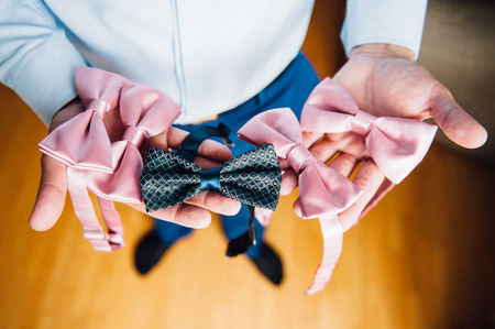 A man chooses a bow tie in his handsの写真素材