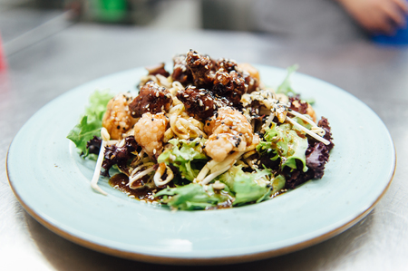 Caesar salad in a white plate on a metal surfaceの写真素材