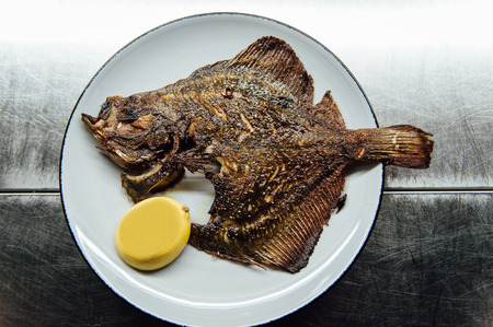 Fried Fish flounder on white plate with lemonの写真素材