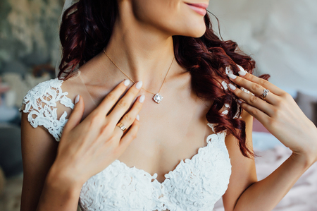 beautiful bride holding a necklace in her hands.の写真素材