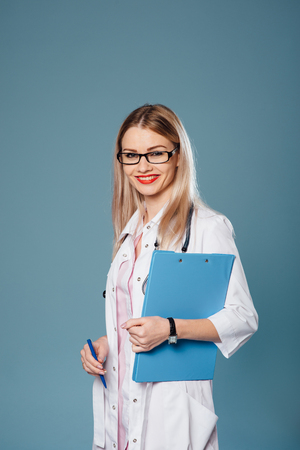 Smiling woman doctor wearing glasses with tabletの写真素材