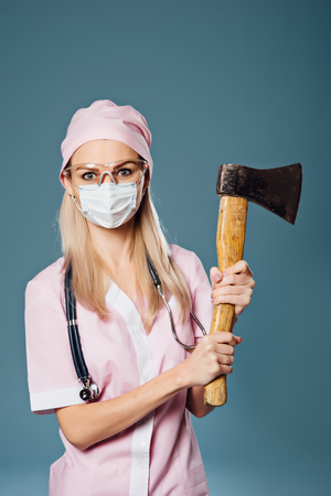 Serious lady doctor in respirator with axの写真素材
