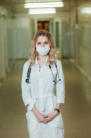woman doctor in a white coat in the corridorの写真素材
