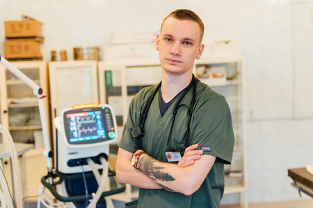 doctor man adjusts medical device with monitorの写真素材