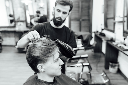 man getting trendy haircut at barber shop.の写真素材