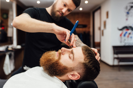 man getting trendy haircut at barber shop.