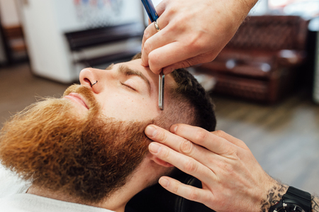 Close up image of barber makes beard cut of a manの写真素材