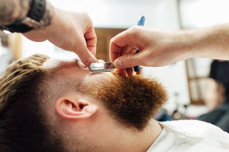 Close up image of barber makes beard cut of a manの写真素材