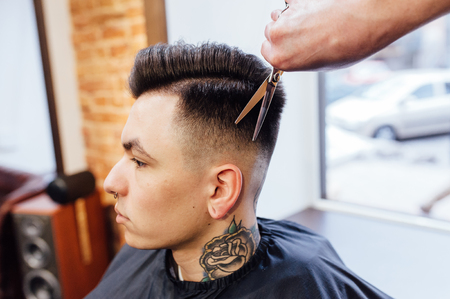 man getting trendy haircut at barber shop.の写真素材