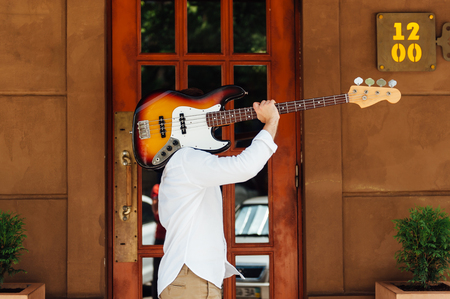 creative guy guitarist carries a guitar on his shoulder