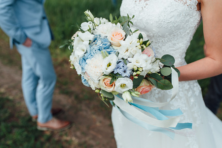 bride in a dress holding a wedding bouquetの写真素材
