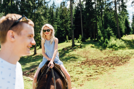 Beautiful couple riding on horses in the mountainsの写真素材