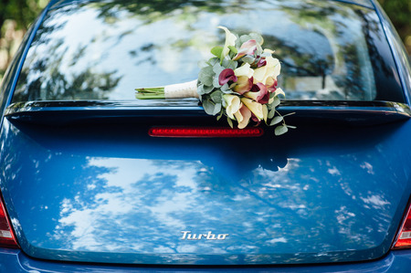 a wedding bouquet lies on a beautiful blue car. wedding decorationsの写真素材