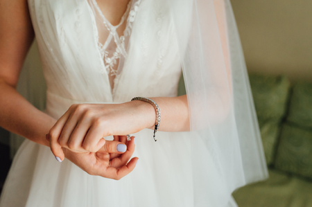 Elegant bridal hand with silver bracelet. Morning bridal preparation with stylish accessories.の写真素材